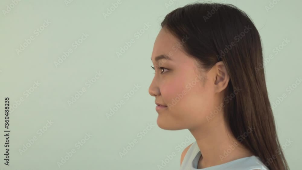 portrait close-up. Asian girl nods according to. The girl is pretty smiling. 4K portrait close-up. Asian girl nods according to. The girl is pretty smiling. 4K