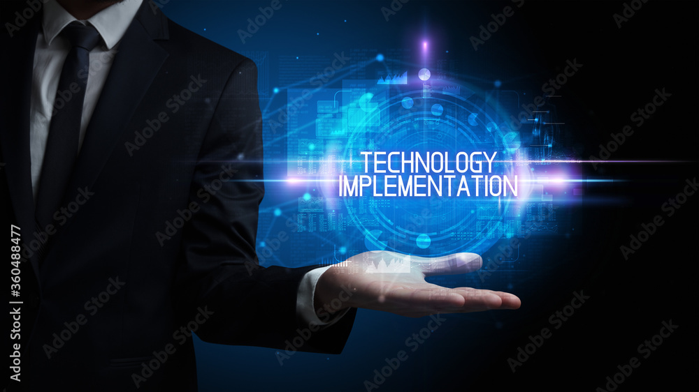 Man hand holding TECHNOLOGY IMPLEMENTATION inscription, technology concept Man hand holding TECHNOLOGY IMPLEMENTATION inscription, technology concept