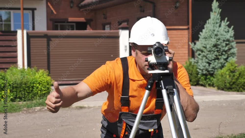 Professional Construction Surveyor Working with Leveling Instrument on Construction Site Professional Construction Surveyor Working with Leveling Instrument on Construction Site