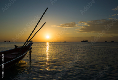 Beautiful sunset on tropical island Koh Tao, Thailand. Boat in water and last sun