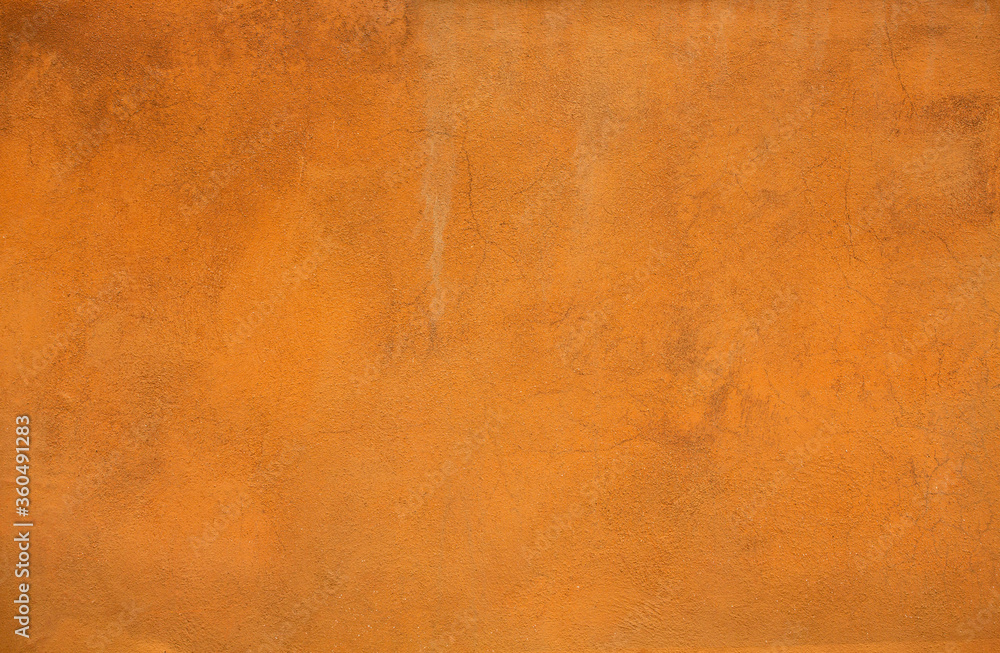 Orange color stucco background or texture. Bright light plastered wall of a building.