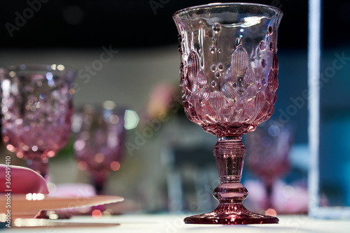 A close up of a glass cup pink vine glass on a table