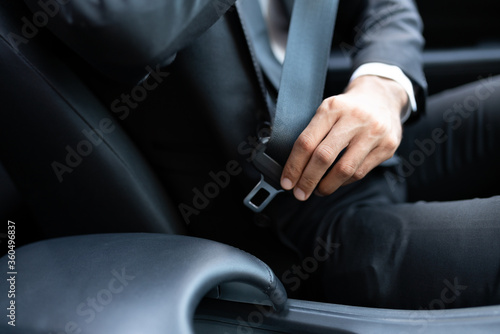 Businessman Adjusting Seat Belt In Car