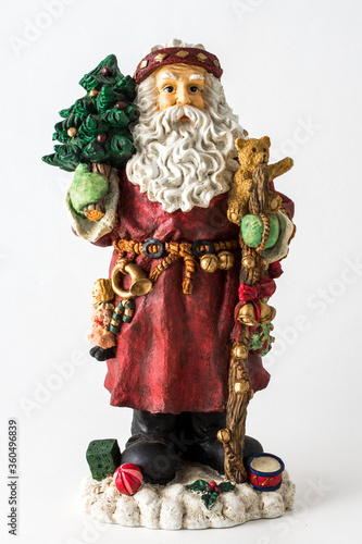a styalized Santa Claus figurine with tree and toys on an isolated white background. photo