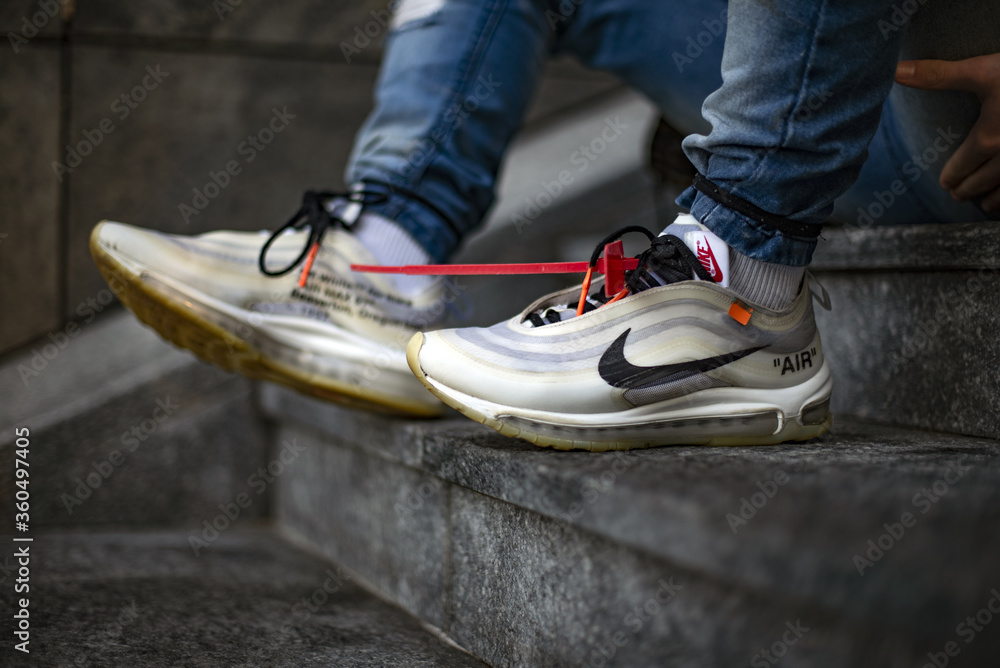 Young man wearing a pair of Nike Air Max 97 Off-White Photos | Adobe Stock