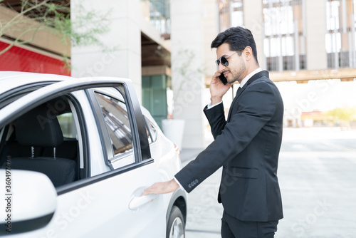 Wallpaper Mural Businessman Talking On Mobile Phone Outside Car Torontodigital.ca