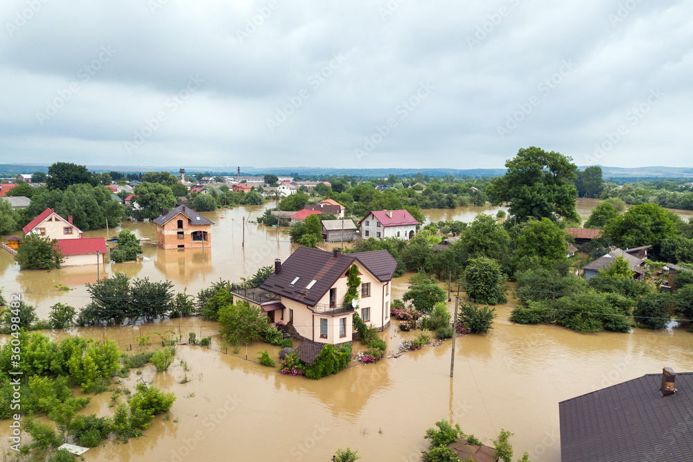 Fototapeta premium Aerial view of flooded houses with dirty water of Dnister river in Halych town, western Ukraine.