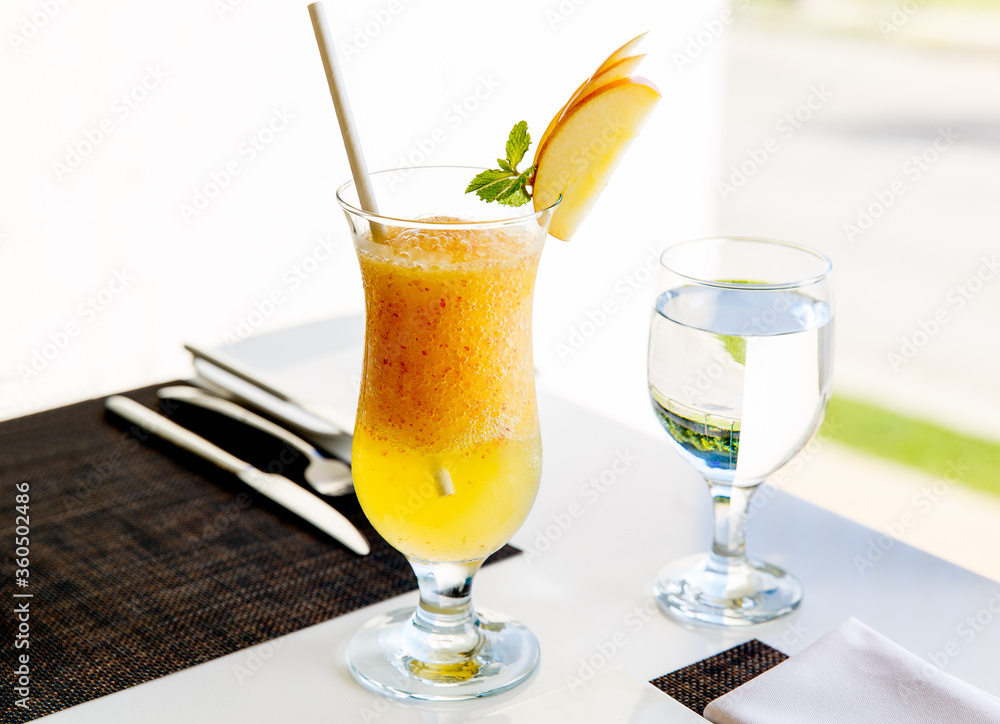 A glass of healthy Apple juice drink with pulp decorated with a slice of Apple and glass of water served on the table. Healthy diet food. A glass of healthy Apple juice drink with pulp decorated with a slice of Apple and glass of water served on the table. Healthy diet food.
