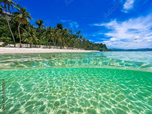 Beautiful landscape on the tropical beach of Boracay island  Philippines. Coconut trees  sea  sailboat and white sand. View of nature. The concept of summer vacation.