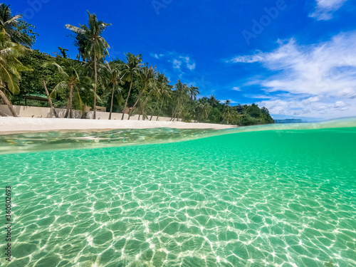 Beautiful landscape on the tropical beach of Boracay island, Philippines. Coconut trees, sea, sailboat and white sand. View of nature. The concept of summer vacation.