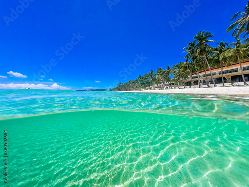 Beautiful landscape on the tropical beach of Boracay island, Philippines. Coconut trees, sea, sailboat and white sand. View of nature. The concept of summer vacation.