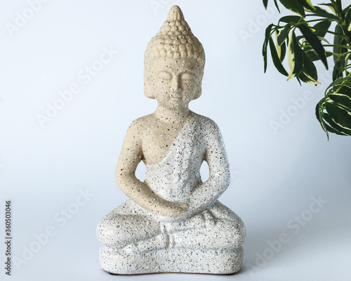 A small statue of Buddha on white background. 
Interior solution.Buddha statue used as amulets of Buddhism religion
