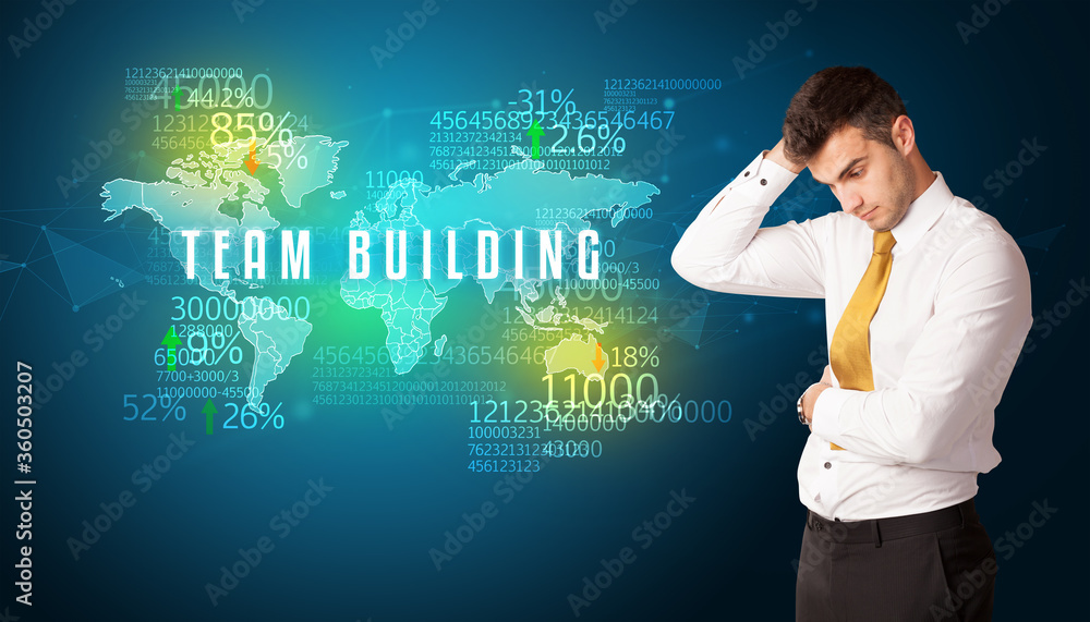 Businessman in front of a decision with TEAM BUILDING inscription, business concept Businessman in front of a decision with TEAM BUILDING inscription, business concept