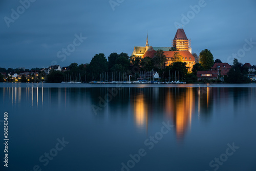 Ratzeburg Dome peninsula in golden light at blue hour evening with beautiful reflection in the water, Schleswig-Holstein, Germany