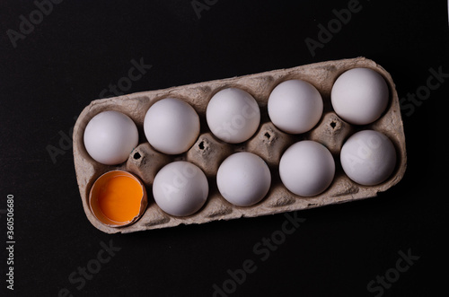 a broken egg in a pack of white eggs