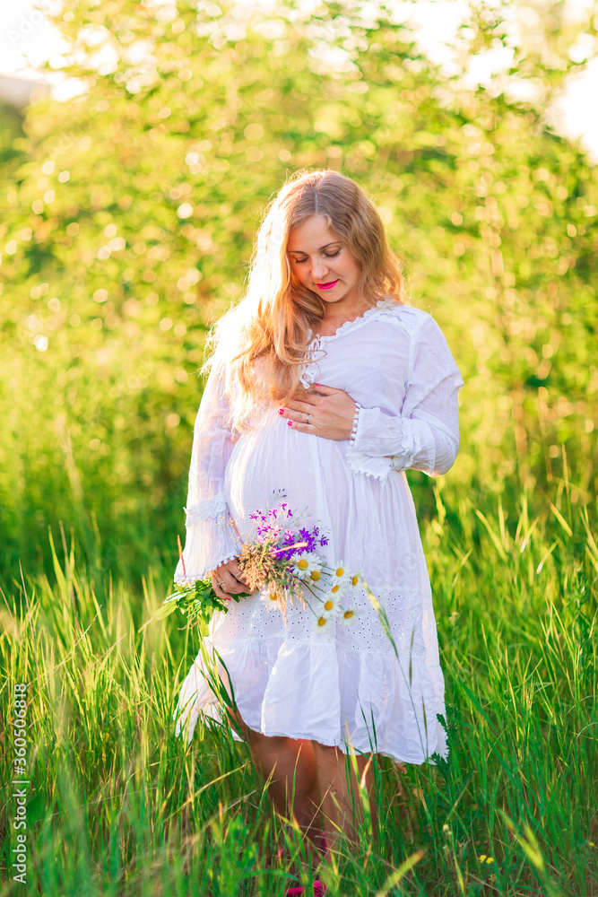 Beautiful young pregnant woman relaxing in nature on a beautiful sunny day. Beautiful young pregnant woman relaxing in nature on a beautiful sunny day.