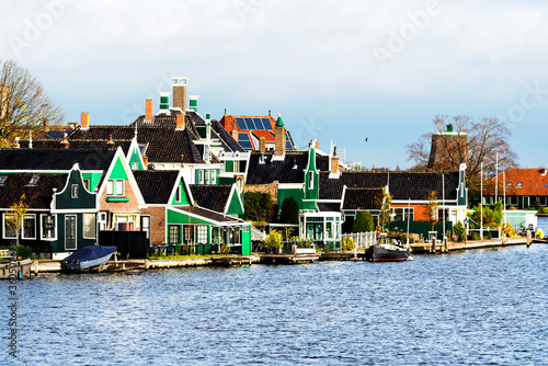 Picturesque view of traditional Houses by the Canal in the Historic Village of Zaanse Schans on the Zaan River in the Netherlands photo