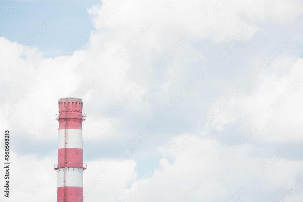 Coal power plant smokestacks emit carbon dioxide pollution by factory under blue sky.
