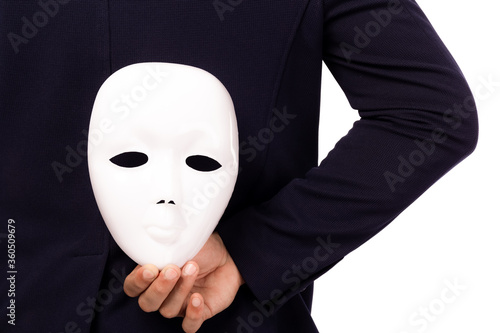 Businessman hide white mask behind back. White collar worker is dishonest cheating. Faking and betray business partnership, dishonest hiding in mask. Cheating person hiding mask. pretend good person