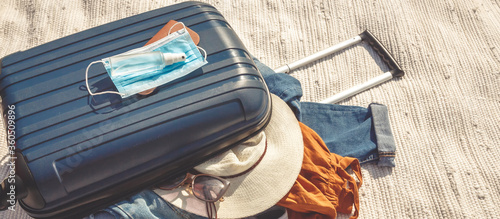 Travel.Todler sits near a suitcase with things and dreams of a vacation traveling after quarantine, lockdown, covid 19. Staycation.local travel.Tourism after the opening of borders, end of quarantine photo