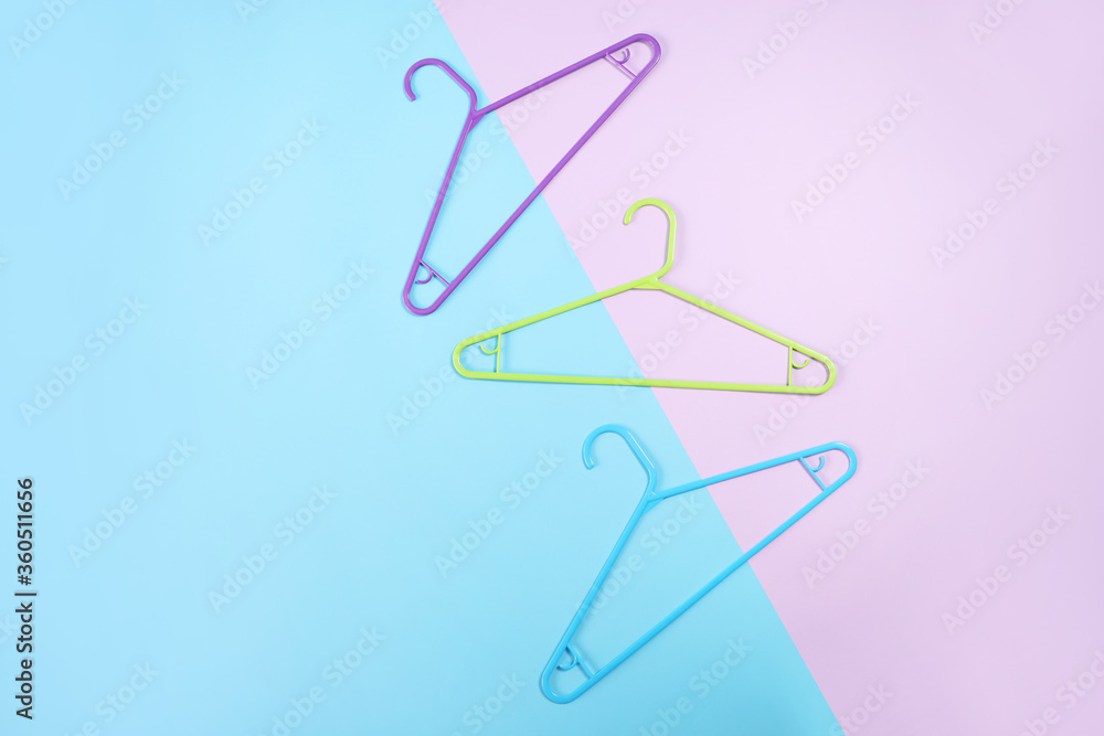 Clothes hangers on blue and pink background, top view. Clothes hangers on blue and pink background, top view.