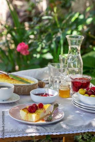 Breakfast in the garden from casseroles, berries, sauces and drinks. Rustic style.