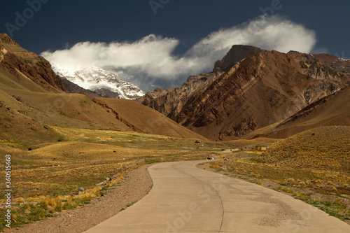 Seven summits. Mountaineering. Path across the golden meadow that leads to mountain Aconcagua with a snowy peak, in Mendoza, Patagonia Argentina.