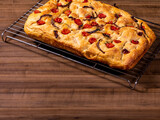 Traditional Italian Focaccia with cherry tomatoes, black olives and rosemary