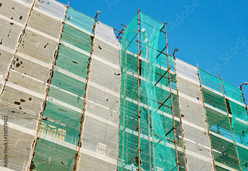 Edificio in costruzione: impalcature e ponteggi con rete di protezione  photo