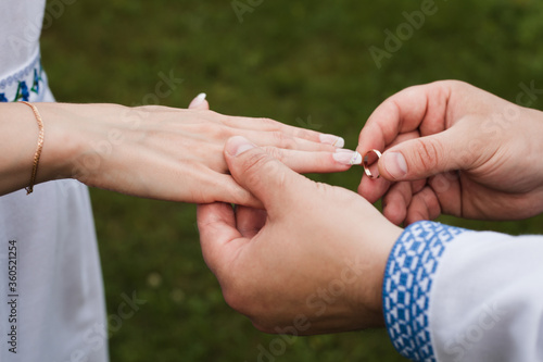 A man puts a wedding ring on a woman. Husband and wife, wedding day. Close-up photo. gold ring 