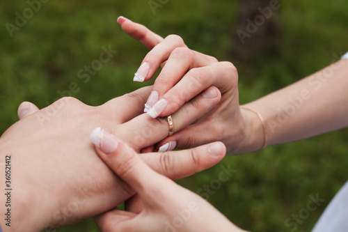 Woman puts a wedding ring on a man. Husband and wife in Ukrainian clothes, embroidery, wedding day. Close-up photo of hands. gold ring  © Nastia