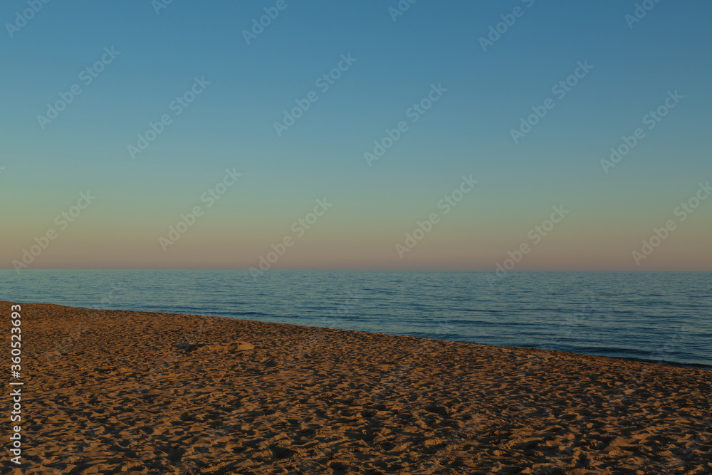 View of a beach on the Italian coast in the Tyrrhenian Sea, in Lazio, at sunset. Sunset over the beach.