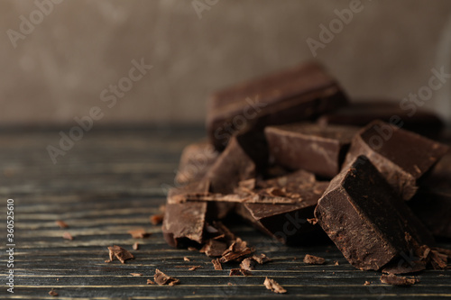Chocolate pieces on wooden background, close up