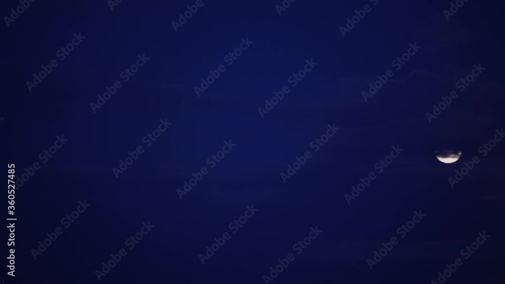 Time lapse at dusk of full moon and clouds