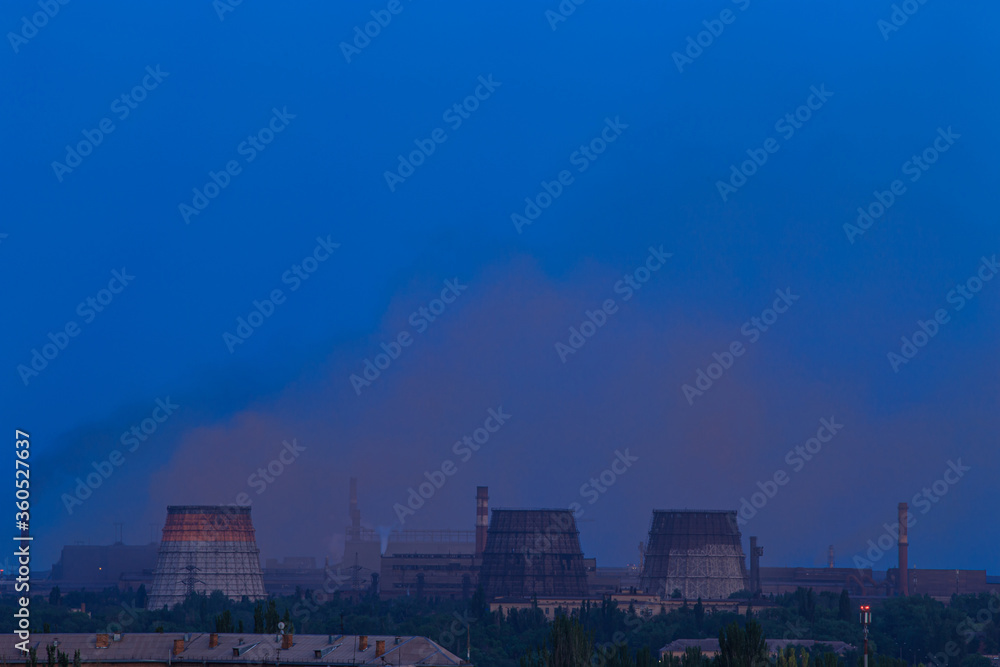 Evening in the city with a large metallurgical plant on the outskirts Evening in the city with a large metallurgical plant on the outskirts