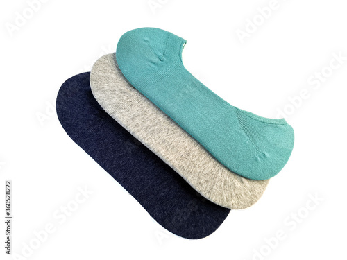 Three pairs of new socks in gray, navy blue and turquoise isolated on a white background. Set of socks are stacked on top of each other.