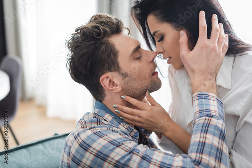 Beautiful woman kissing handsome boyfriend at home