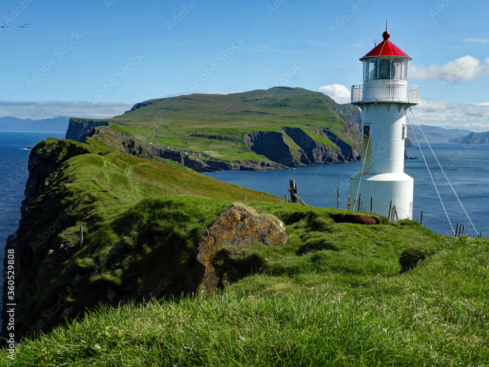 The lighthouse on Mykines, Faroe Islands with a view on the island. 