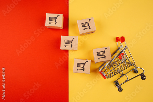 Paper brown boxes and trolley isolate on colorful background. The concept of delivery of goods from the online store to the house.
