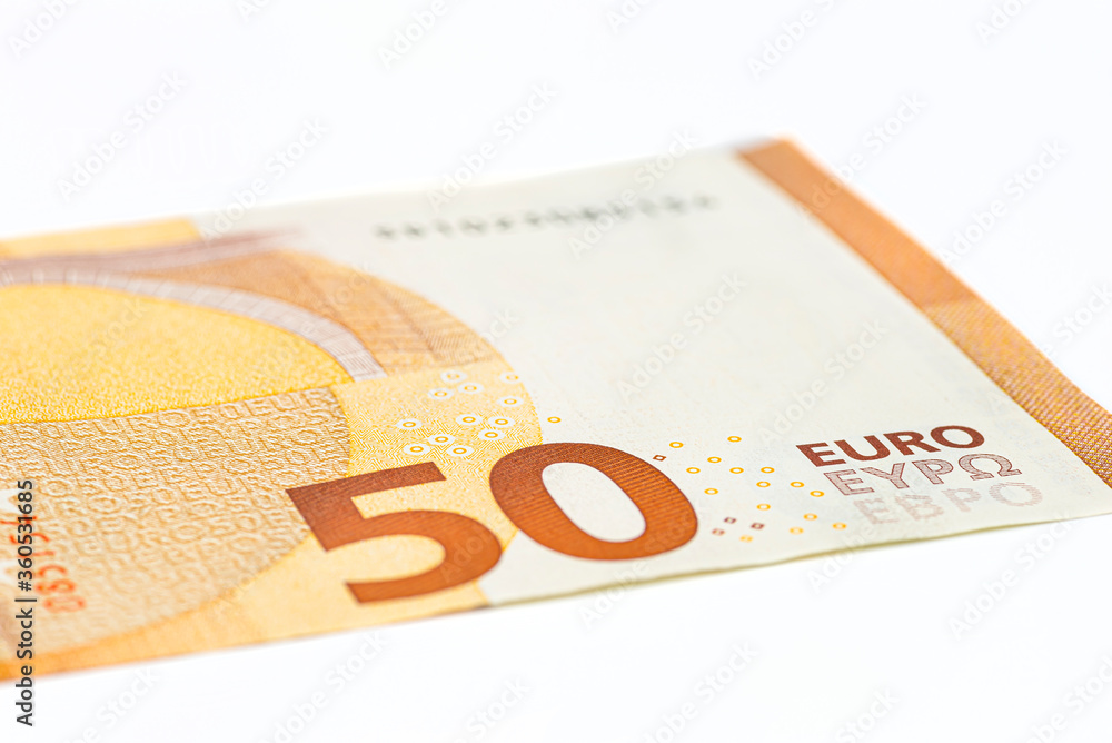 Obraz premium Macro shot of a European Union banknote of 50 EUR, close-up of the number fifty, isolated on a white background, selective focus.