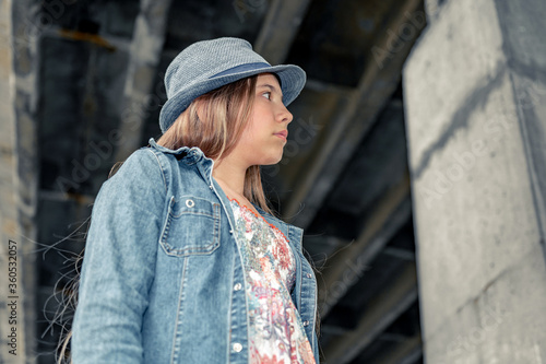 Teenage girl outdoors. Portrait of a beautiful sad girl in a blue hat © andyborodaty
