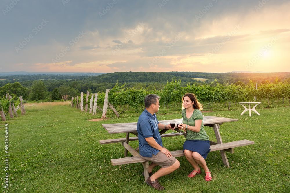 couple at a winery sipping wine at sunset couple at a winery sipping wine at sunset