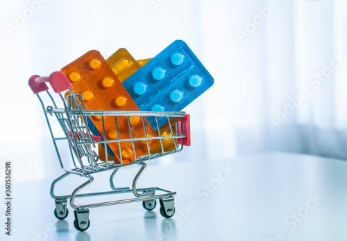 pack of medicines pills in the shop trolley on the light background photo