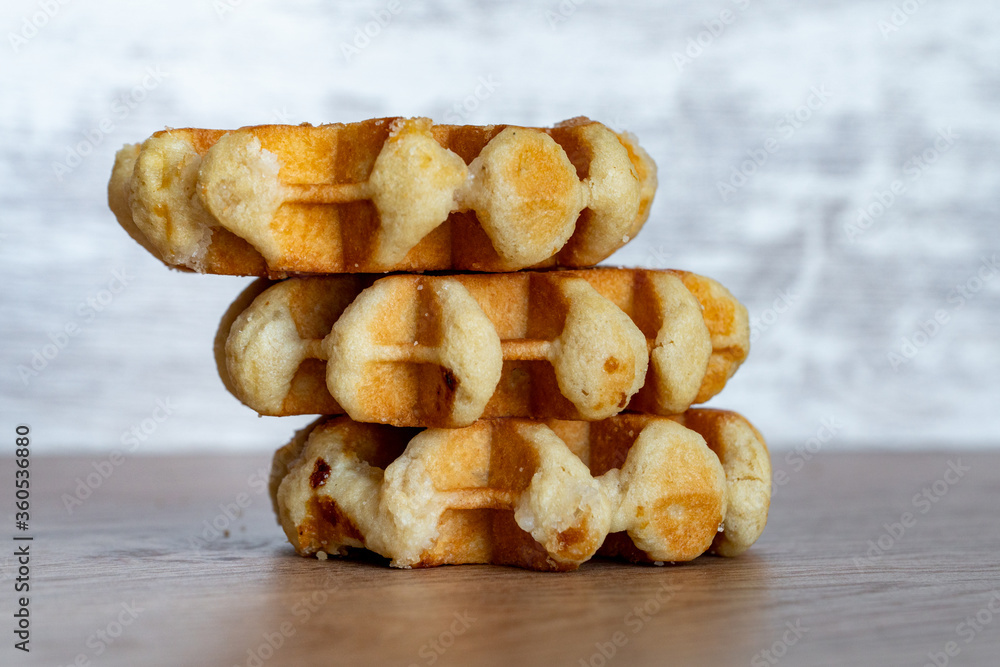 A delicious baked round Belgian waffle with one bite taken.