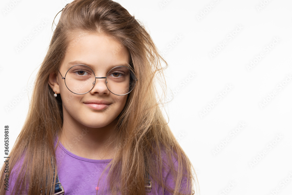 Portrait of a very beautiful girl of eleven years in glasses on a white background
