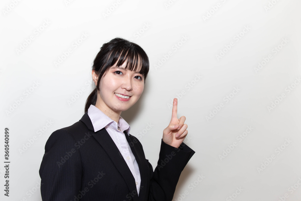 スーツ姿で指を差す若い女性 Stock Photo Adobe Stock