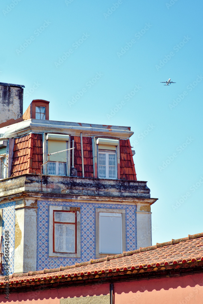 Plane in the sky over an old building in Lisbon, Portugal