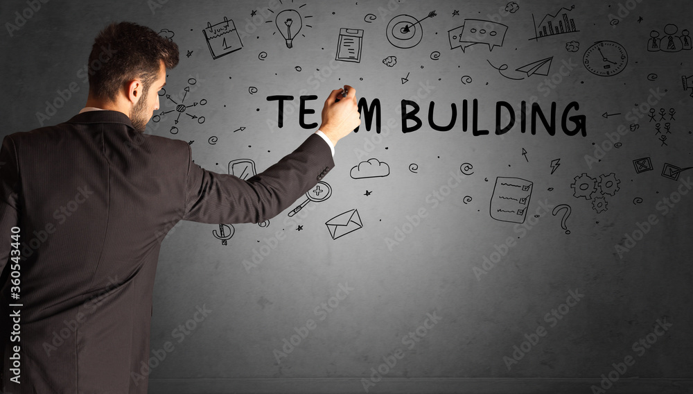businessman drawing a creative idea sketch with TEAM BUILDING inscription, business strategy concept