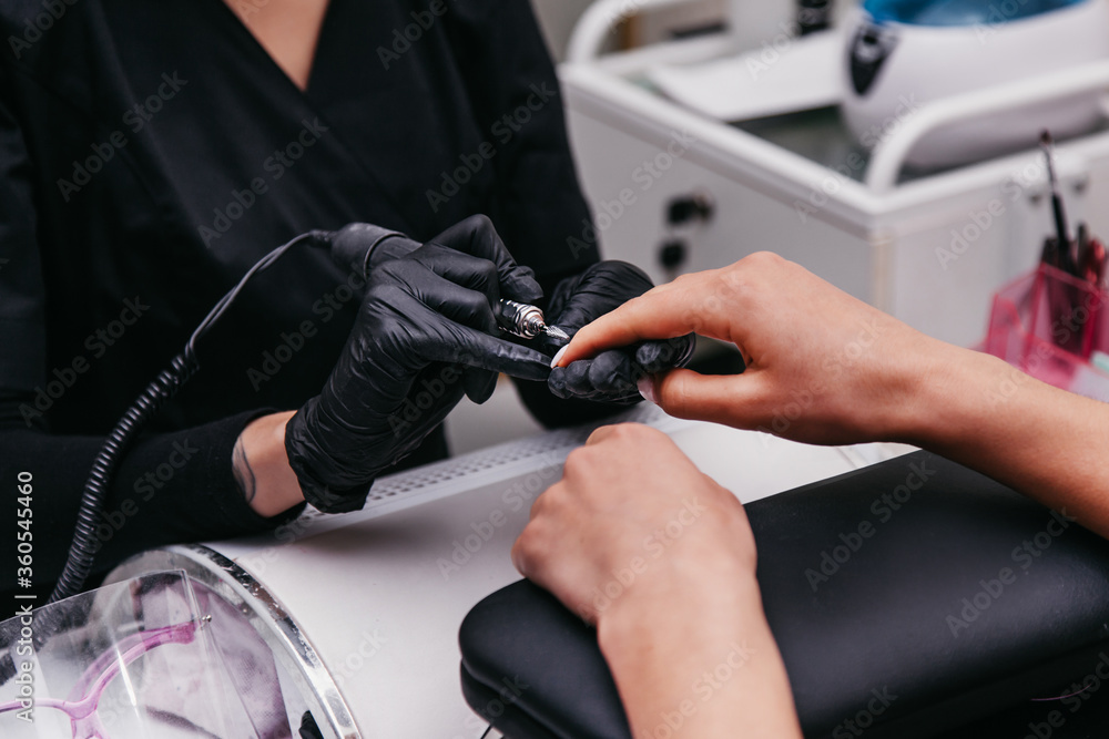 manicurist makes nails to a client