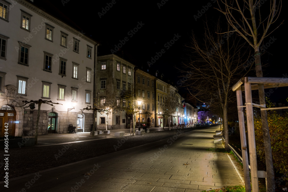 Empty capitol of Slovenia Ljubljana city at night. Old historic buildings on the left. Promenade near Ljubljanica river